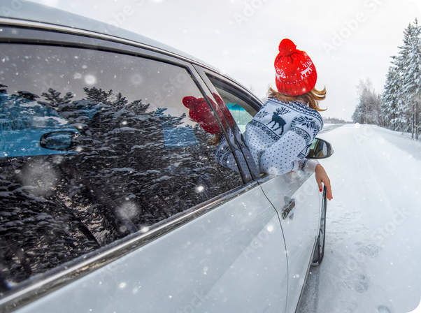 Woman with head out of car in the snow